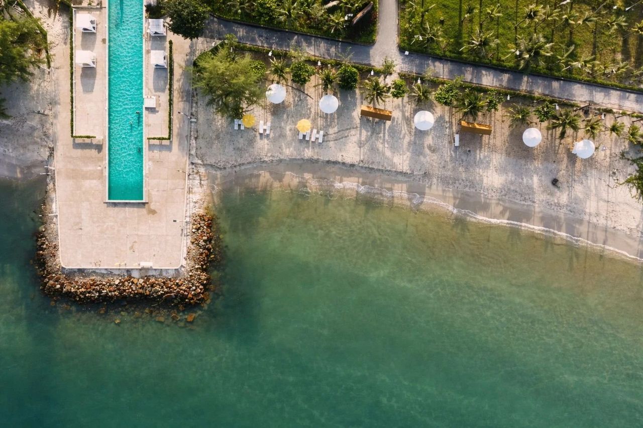 Aerial over an overwater resort — the cinematic standard for a hotel video